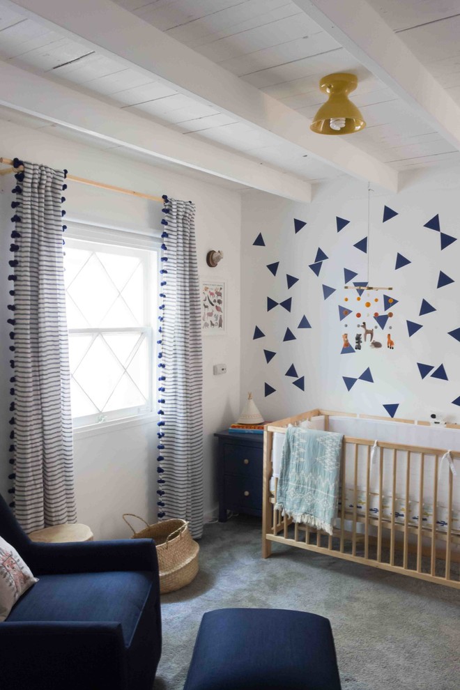 Photo of a mid-sized eclectic nursery for boys in Los Angeles with white walls, carpet and grey floor.
