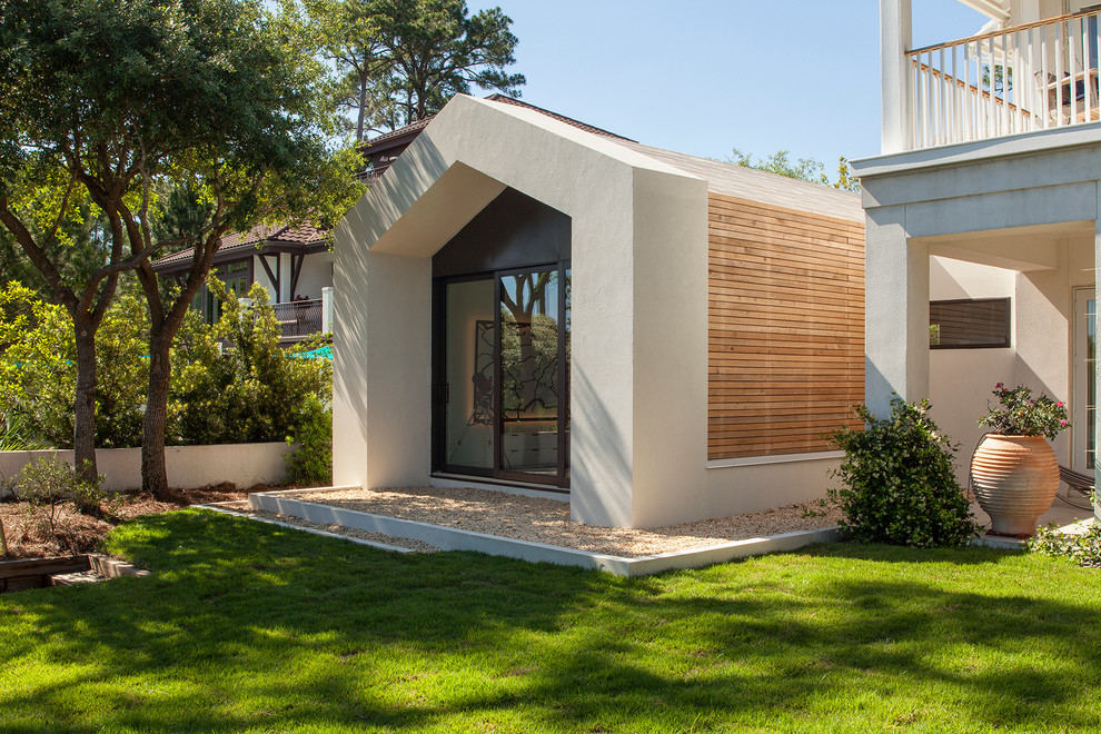 Small contemporary one-storey white exterior in Miami with wood siding and a gable roof.