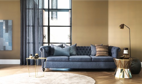 blue chesterfield sofa with large round circular rug