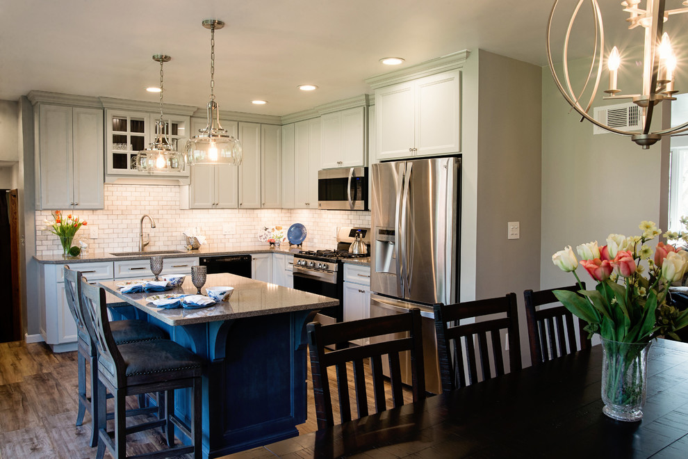Inspiration for a mid-sized transitional l-shaped vinyl floor eat-in kitchen remodel with an undermount sink, recessed-panel cabinets, gray cabinets, quartz countertops, white backsplash, marble backsplash, stainless steel appliances and an island