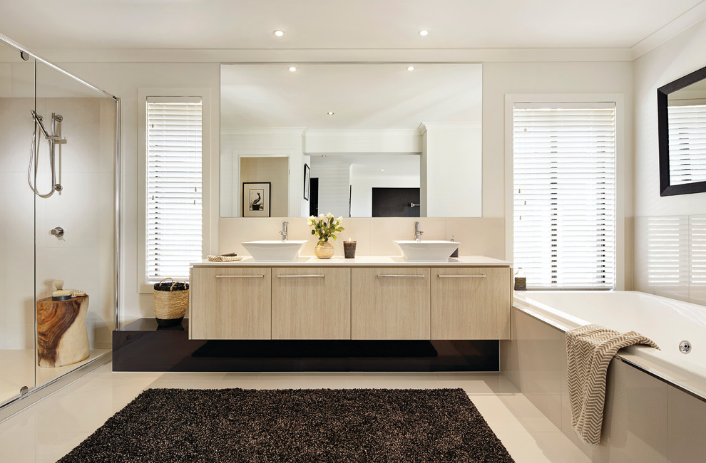 Photo of a beach style bathroom in Melbourne with furniture-like cabinets, light wood cabinets, beige tile, porcelain tile and beige walls.