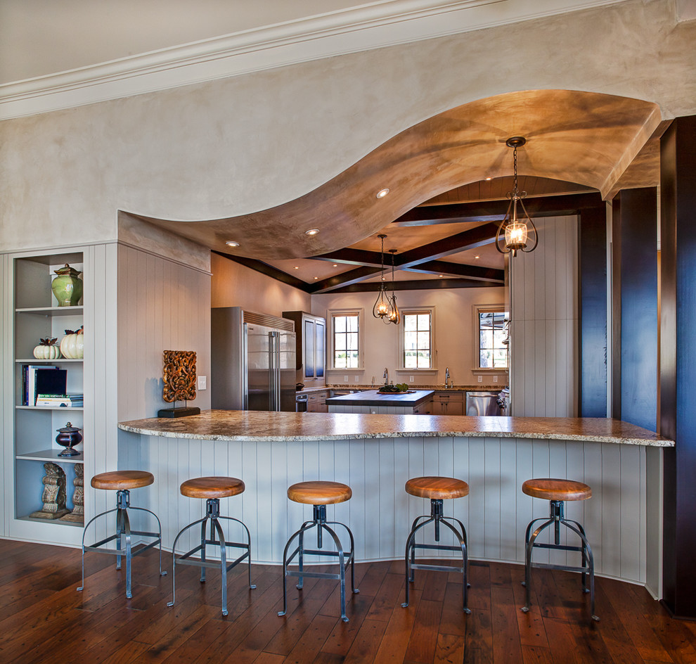 Inspiration for a large mediterranean u-shaped kitchen in Charlotte with stainless steel appliances, medium hardwood floors and multiple islands.