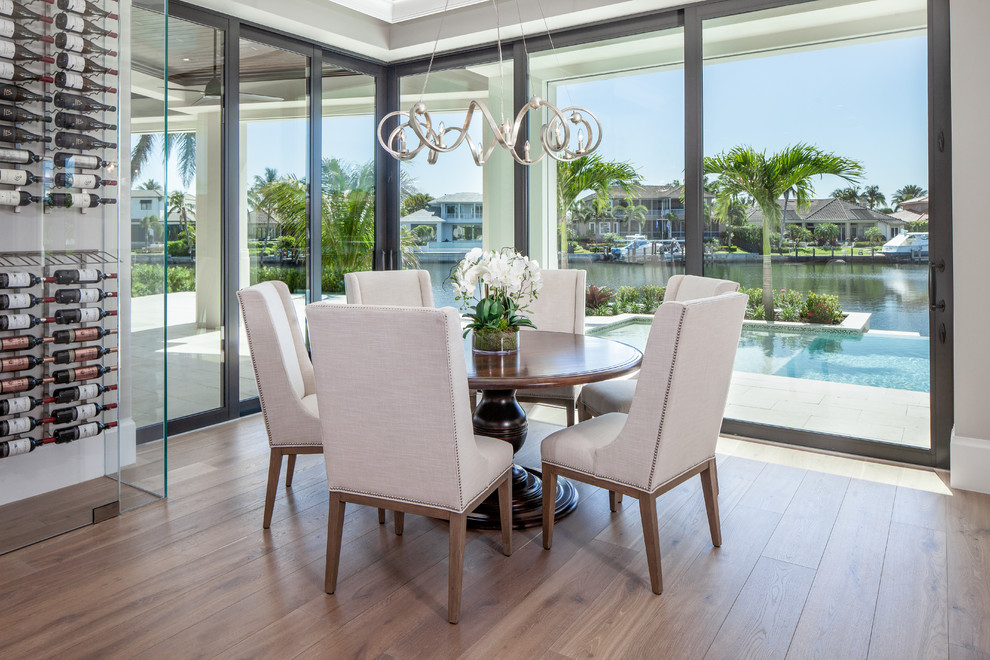 Design ideas for a transitional open plan dining in Miami with beige walls and light hardwood floors.