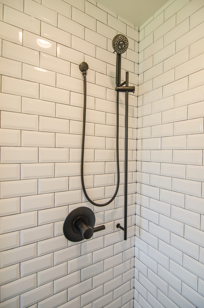 Photo of a small contemporary master bathroom in DC Metro with shaker cabinets, white cabinets, an alcove shower, a two-piece toilet, black and white tile, ceramic tile, porcelain floors, an integrated sink, solid surface benchtops, black floor, a sliding shower screen and white benchtops.