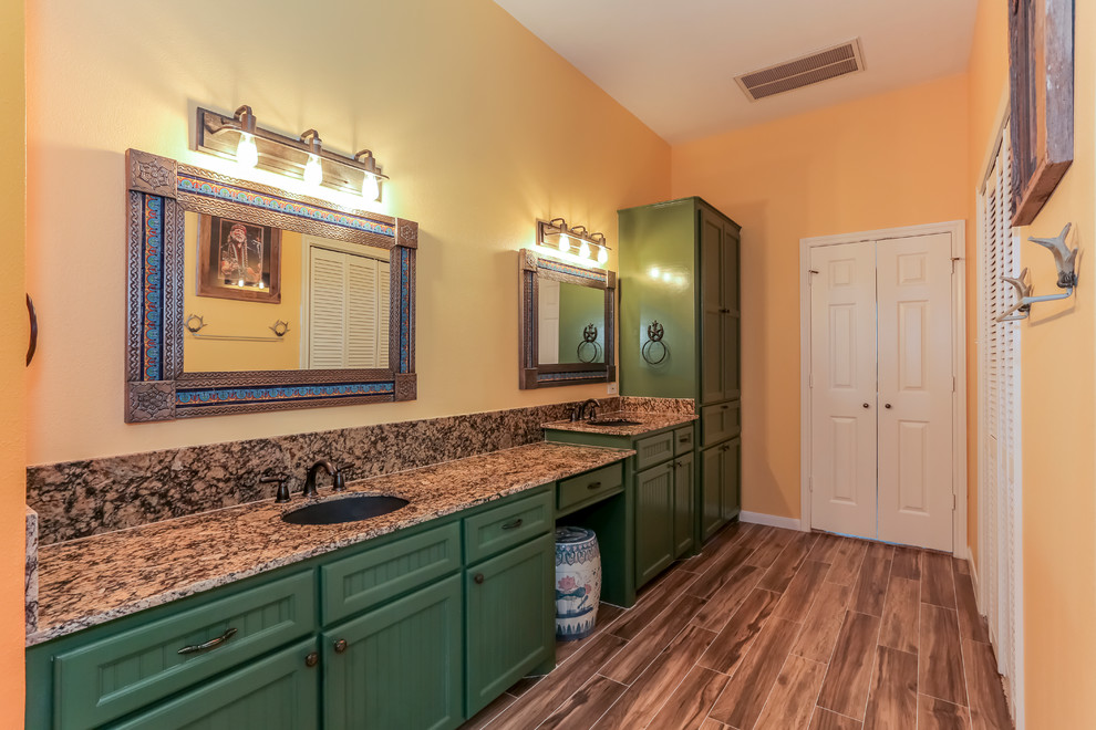 Large master bathroom in Houston with beaded inset cabinets, green cabinets, a double shower, a two-piece toilet, brown tile, porcelain tile, orange walls, porcelain floors, an undermount sink and granite benchtops.