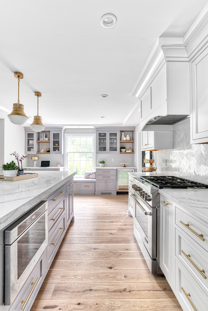 Design ideas for a large transitional u-shaped eat-in kitchen in New York with an undermount sink, beaded inset cabinets, white cabinets, quartz benchtops, white splashback, mosaic tile splashback, panelled appliances, with island and white benchtop.