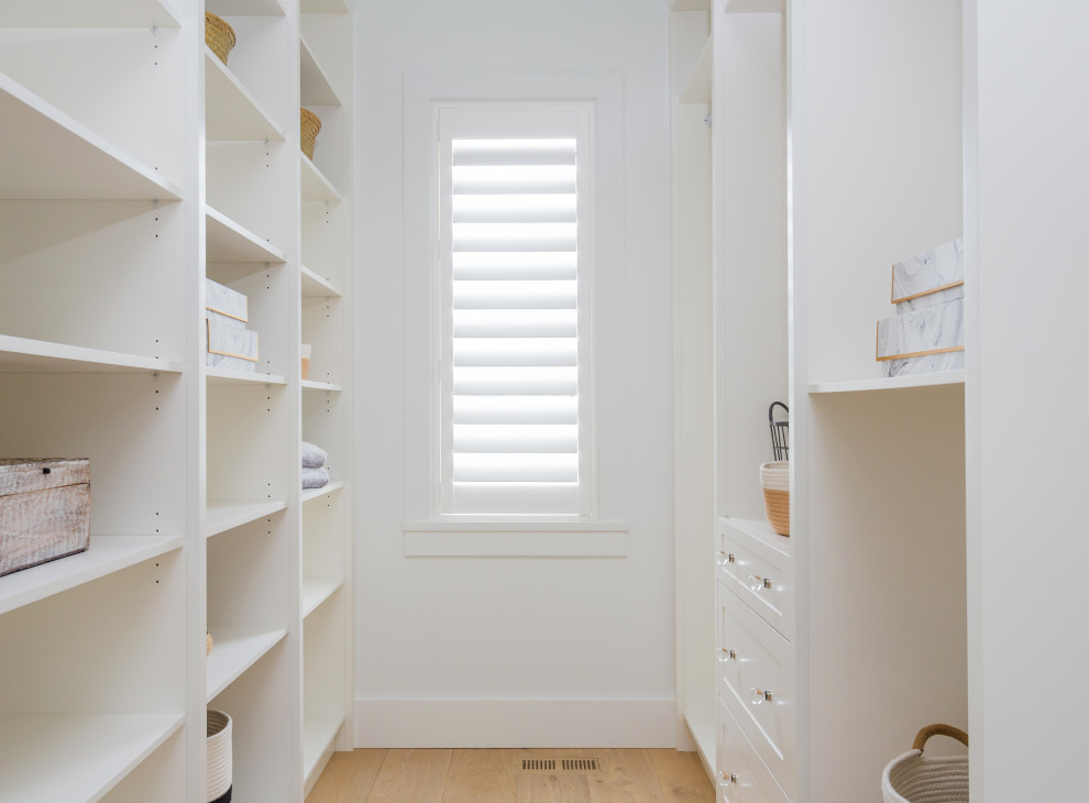 Medium sized country gender neutral walk-in wardrobe in Vancouver with shaker cabinets, white cabinets, light hardwood flooring and beige floors.
