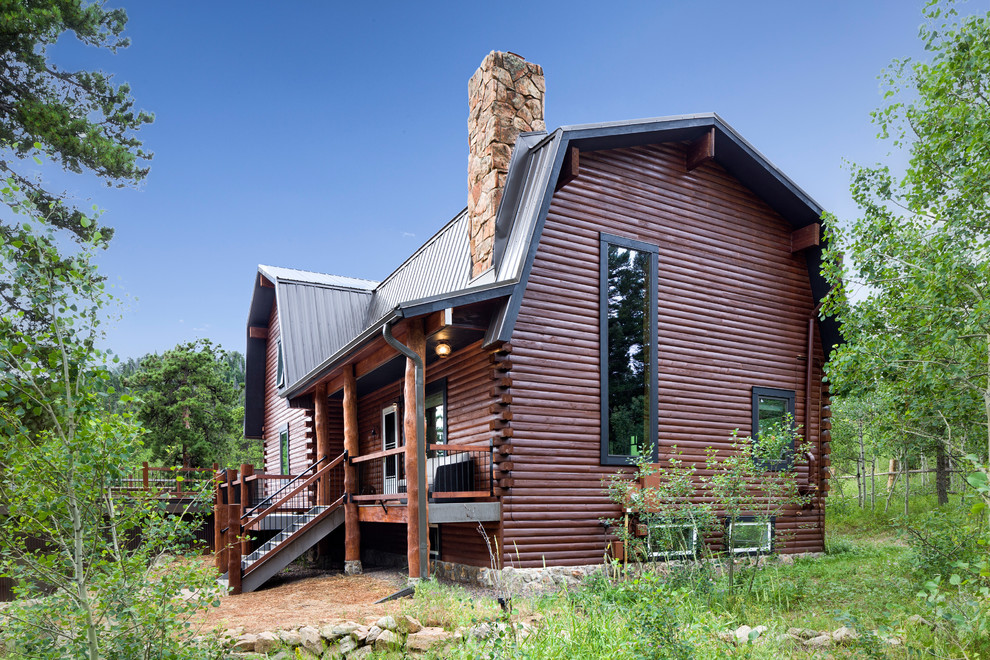 Large mountain style brown three-story wood house exterior photo in Denver with a metal roof