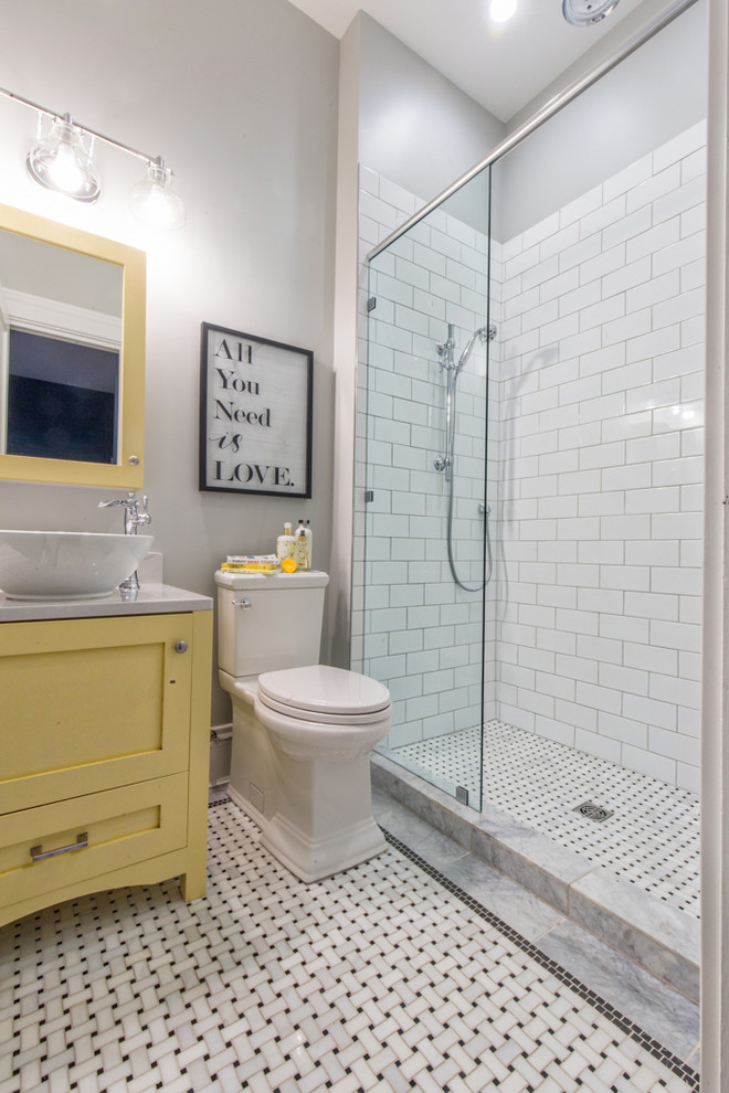 Photo of a small traditional 3/4 bathroom in Other with shaker cabinets, yellow cabinets, an alcove shower, a two-piece toilet, white tile, subway tile, grey walls, marble floors, a vessel sink, engineered quartz benchtops, white floor and an open shower.