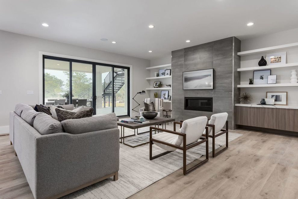 Inspiration for a large transitional walk-out basement in Salt Lake City with grey walls, vinyl floors, a standard fireplace, a tile fireplace surround and beige floor.