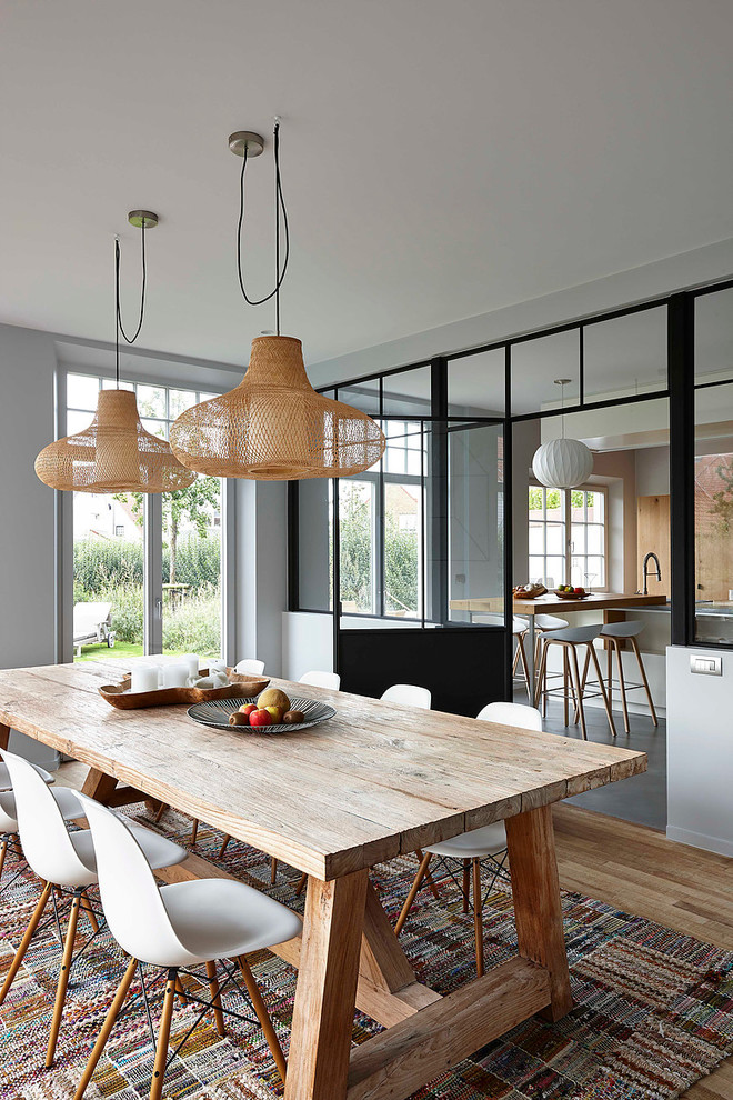 This is an example of a mid-sized contemporary separate dining room in Paris with grey walls and light hardwood floors.