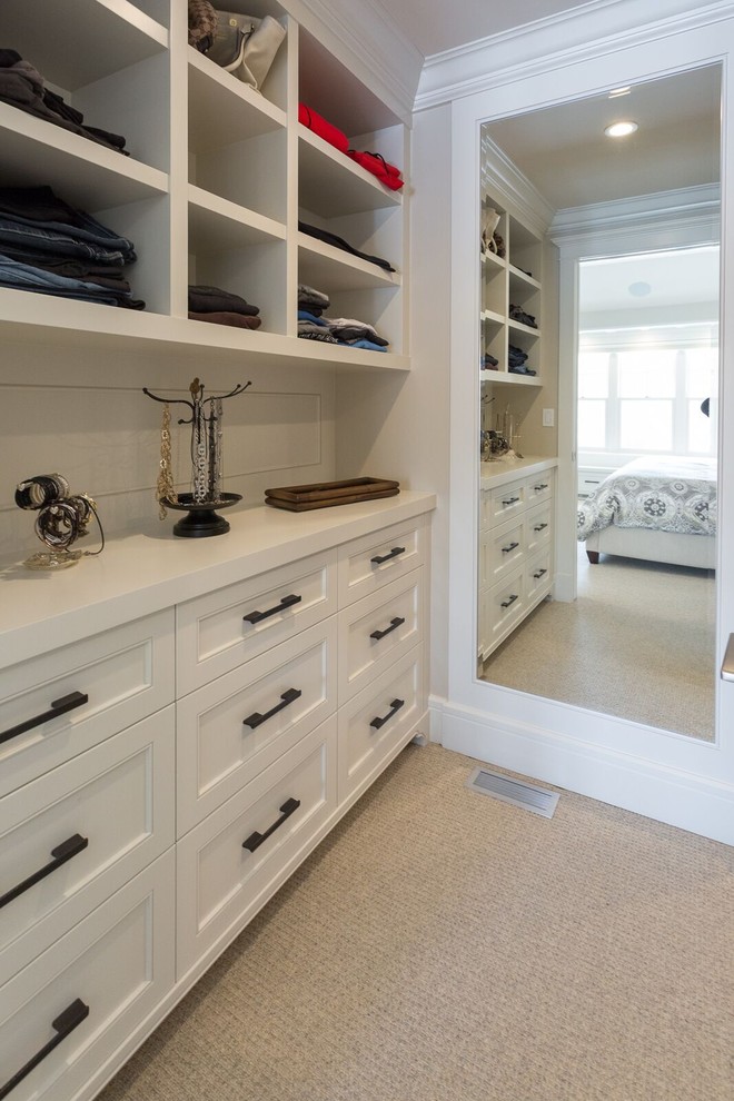 Design ideas for a large traditional gender-neutral walk-in wardrobe in Calgary with open cabinets, white cabinets and carpet.