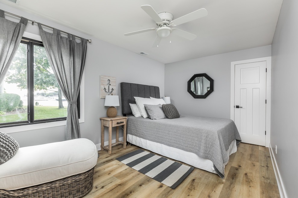 Design ideas for a beach style guest bedroom in Indianapolis with grey walls and light hardwood floors.