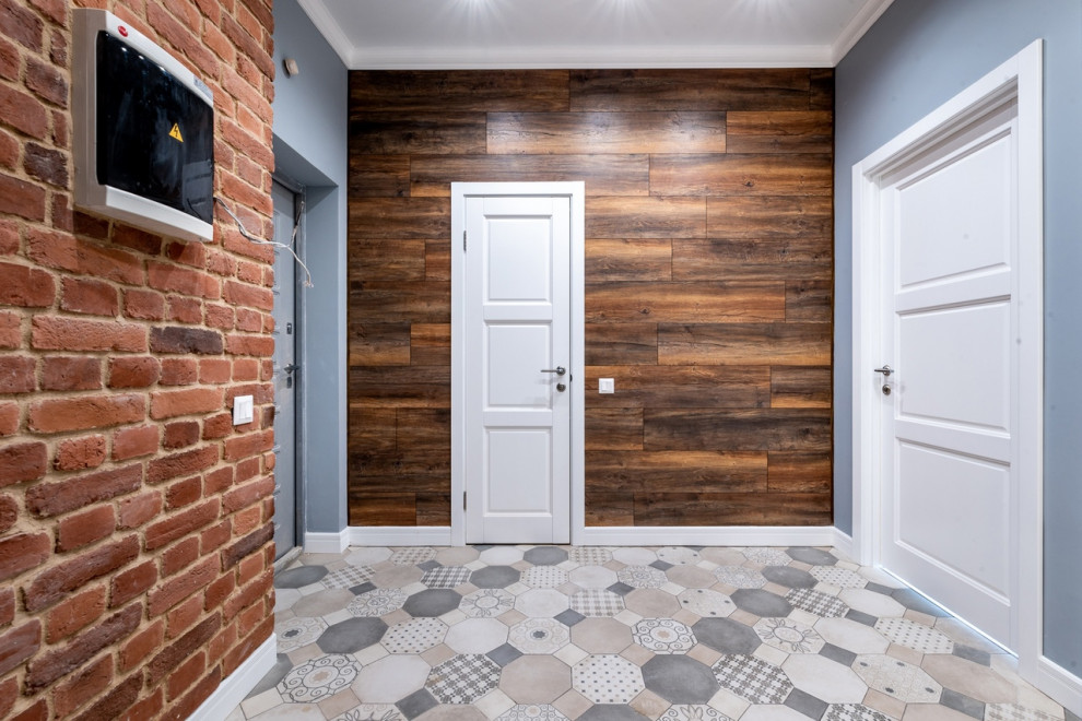 Immagine di un grande ingresso o corridoio design con pavimento in gres porcellanato e pareti in mattoni