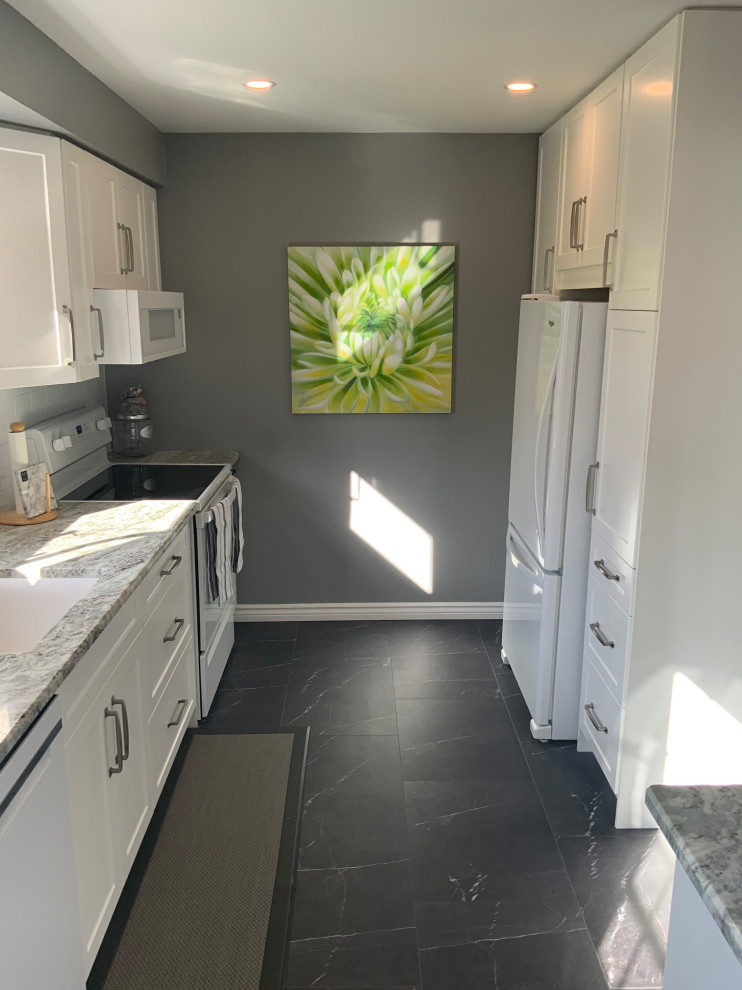 Inspiration for a small transitional galley laminate floor and gray floor kitchen pantry remodel with an undermount sink, shaker cabinets, white cabinets, granite countertops, white backsplash, subway tile backsplash, white appliances, no island and white countertops