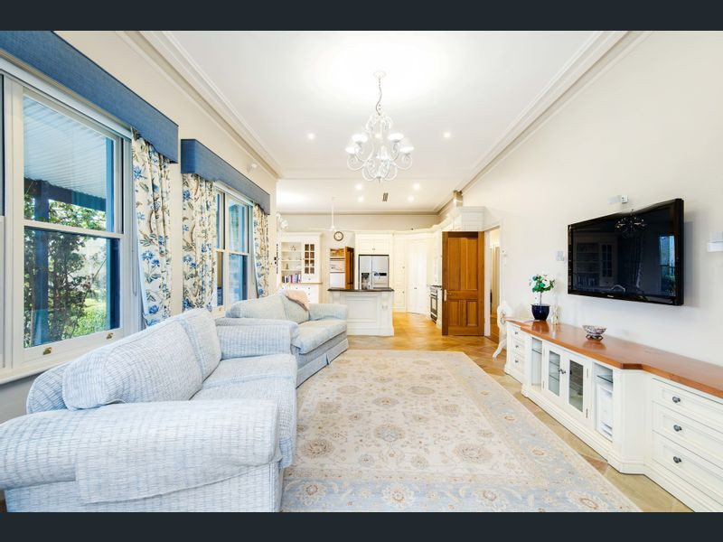 Ejemplo de sala de estar clásica grande con paredes beige, suelo de baldosas de terracota y televisor colgado en la pared