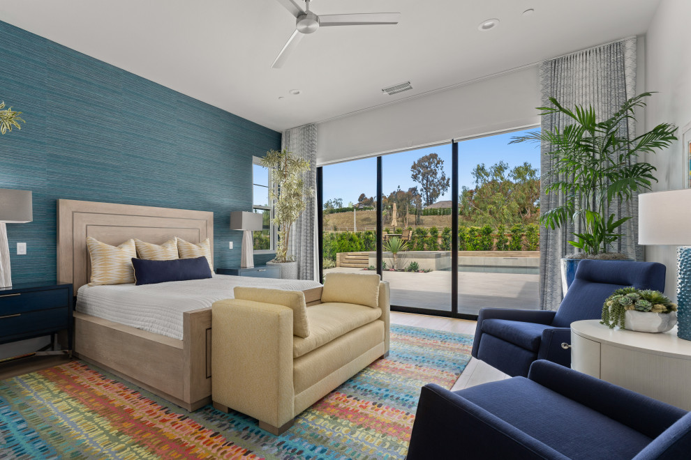 Großes Modernes Hauptschlafzimmer mit blauer Wandfarbe, hellem Holzboden und Tapetenwänden in Orange County