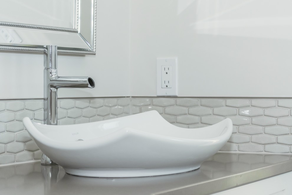 Example of a large transitional master gray tile and ceramic tile porcelain tile freestanding bathtub design in Toronto with a vessel sink, white cabinets, quartz countertops and white walls