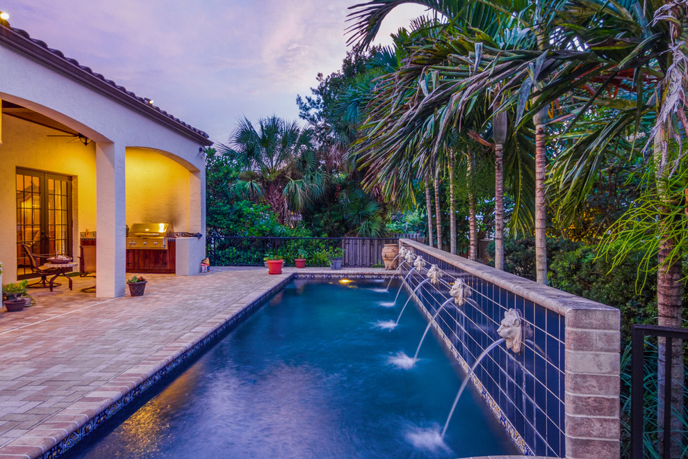 This is an example of a mediterranean lap pool in Tampa with a water feature.