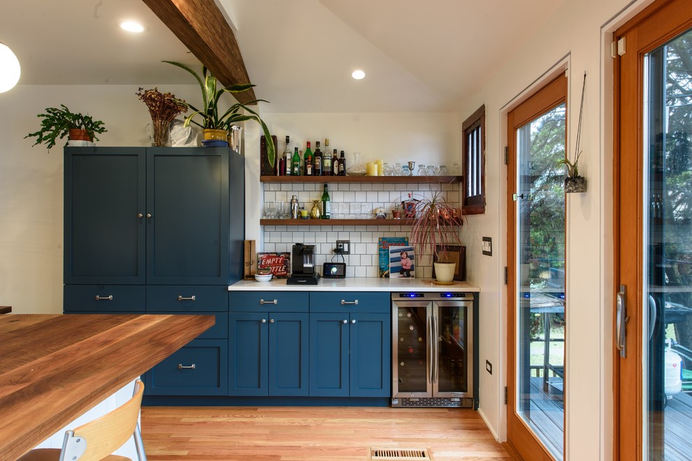Transitional light wood floor and brown floor kitchen photo in Chicago with shaker cabinets, blue cabinets, white backsplash, subway tile backsplash and stainless steel appliances