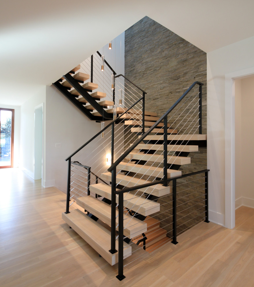 Inspiration for a large bohemian wood floating metal railing staircase in DC Metro with brick walls.