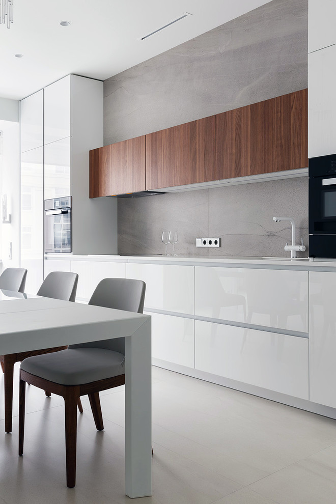 Design ideas for a contemporary single-wall eat-in kitchen in Saint Petersburg with flat-panel cabinets, white cabinets, grey splashback, grey floor and white benchtop.