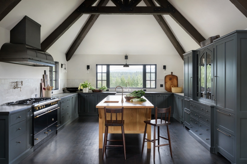 Kitchen - mediterranean u-shaped dark wood floor and brown floor kitchen idea in Portland with a farmhouse sink, shaker cabinets, gray cabinets, white backsplash, black appliances, an island and gray countertops