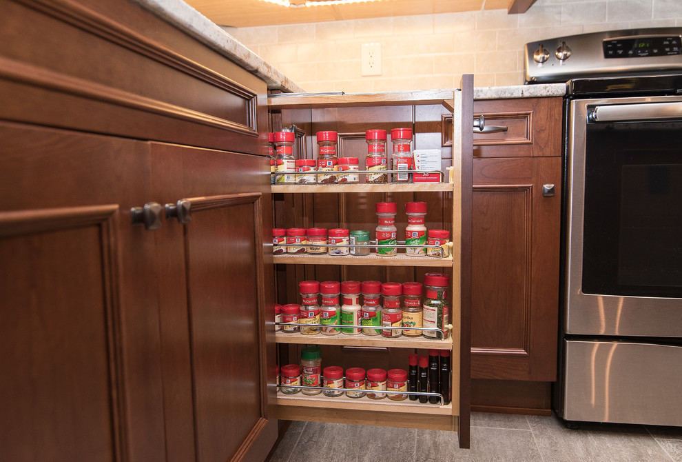 Example of a large classic l-shaped vinyl floor and beige floor eat-in kitchen design in Baltimore with an undermount sink, shaker cabinets, medium tone wood cabinets, granite countertops, beige backsplash, ceramic backsplash, stainless steel appliances, an island and white countertops