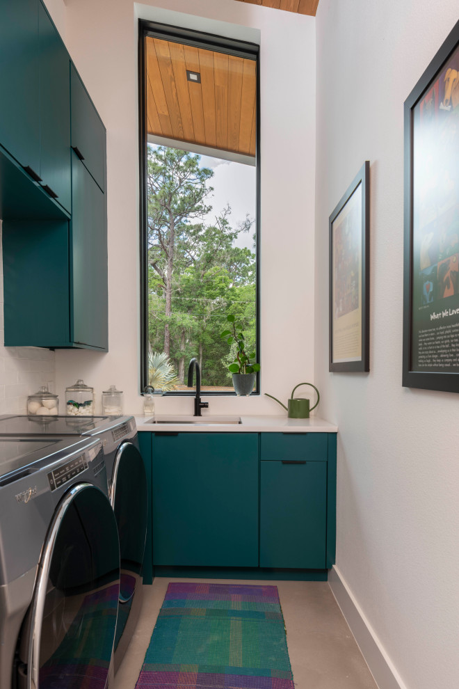 Inspiration for a modern l-shaped gray floor laundry room remodel in Orlando with an undermount sink, flat-panel cabinets, turquoise cabinets, white walls, a side-by-side washer/dryer and white countertops