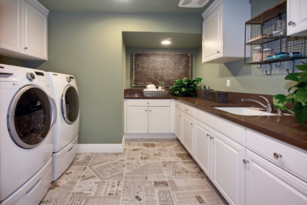 Design ideas for a traditional u-shaped dedicated laundry room in Orange County with an undermount sink, raised-panel cabinets, white cabinets, green walls, a side-by-side washer and dryer and brown benchtop.