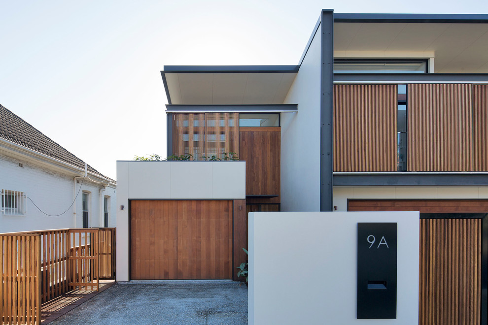 Inspiration for a mid-sized contemporary two-storey townhouse exterior in Sydney with wood siding and a flat roof.