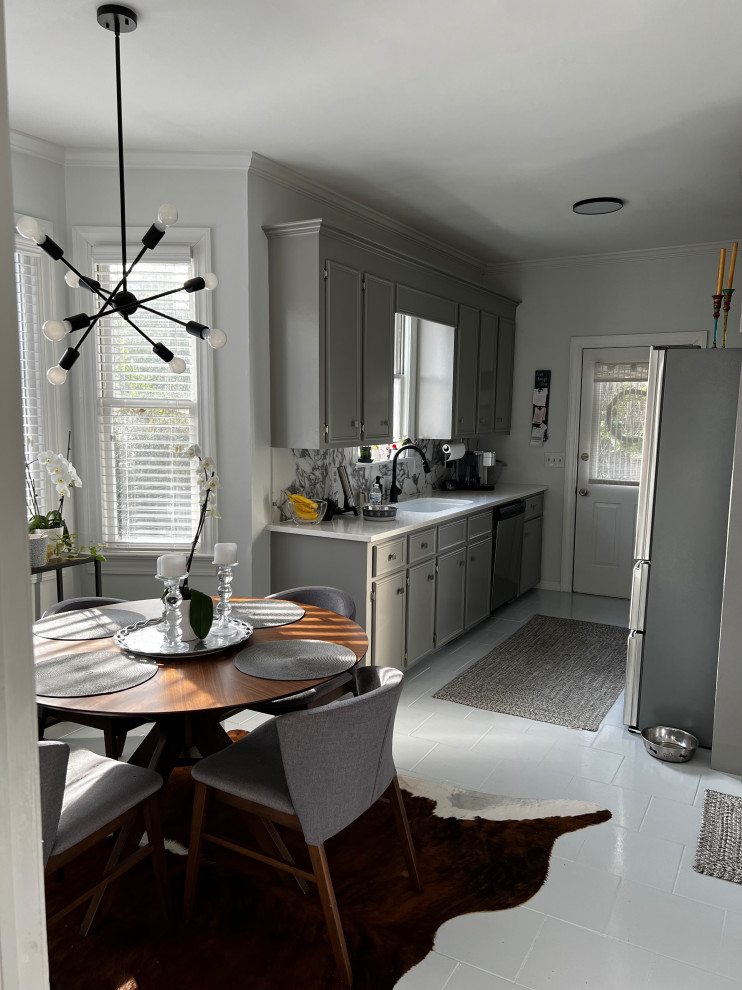 Kitchen - small transitional galley gray floor kitchen idea with a drop-in sink, gray cabinets, quartz countertops, multicolored backsplash, stainless steel appliances and white countertops