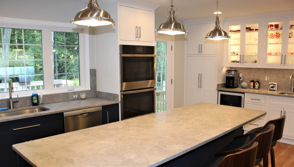 Kitchen pantry - large transitional u-shaped light wood floor kitchen pantry idea in DC Metro with recessed-panel cabinets, blue cabinets, granite countertops, gray backsplash, ceramic backsplash, stainless steel appliances and an island