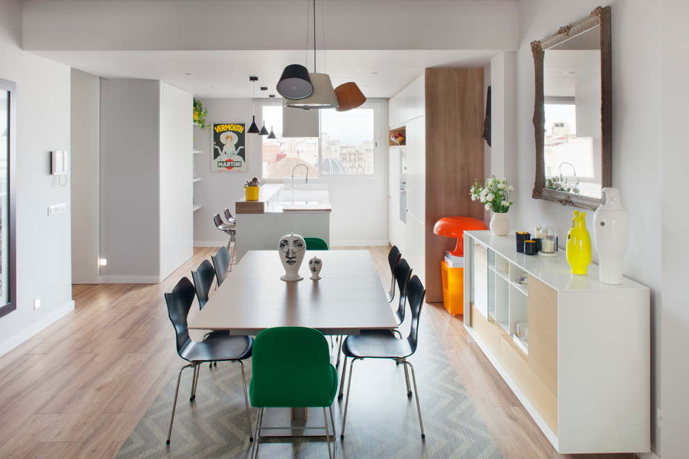 Photo of a mid-sized contemporary kitchen/dining combo in Valencia with white walls and medium hardwood floors.