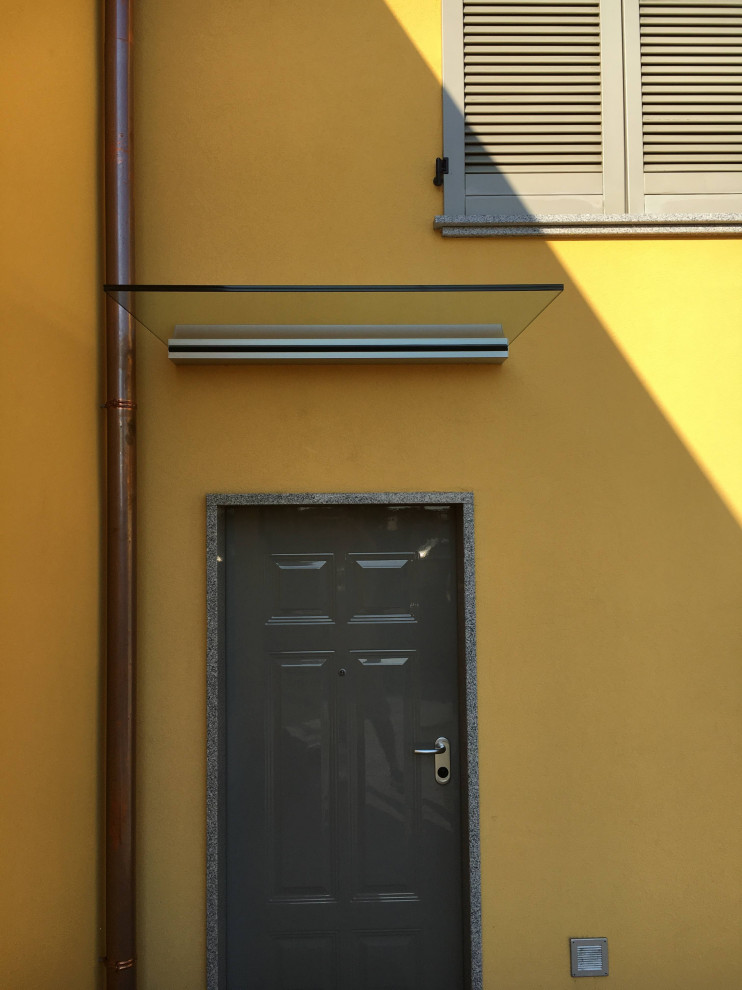 Exemple d'une façade de maison jaune tendance en béton de taille moyenne et à un étage.