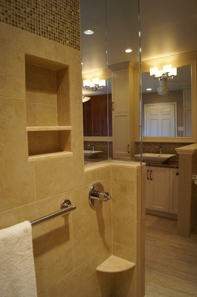 This is an example of a transitional master bathroom in Philadelphia with travertine floors and granite benchtops.