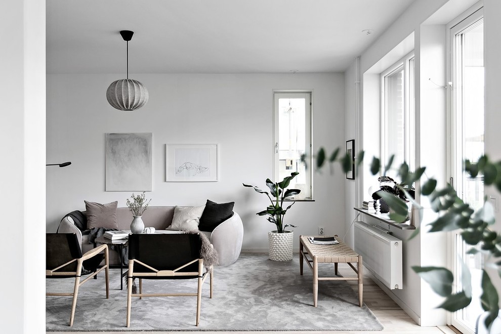 Inspiration for a scandinavian living room in Stockholm with white walls, light hardwood floors and beige floor.