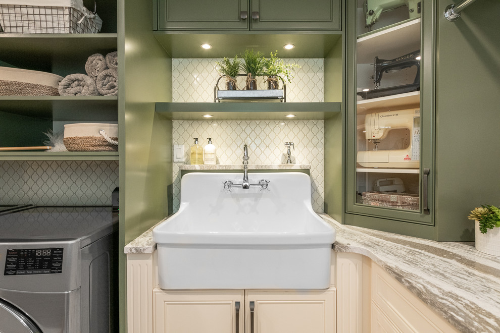 Photo of a mid-sized traditional l-shaped dedicated laundry room in Ottawa with a farmhouse sink, beige walls, a side-by-side washer and dryer, beaded inset cabinets, green cabinets, quartz benchtops, porcelain floors, white floor and multi-coloured benchtop.