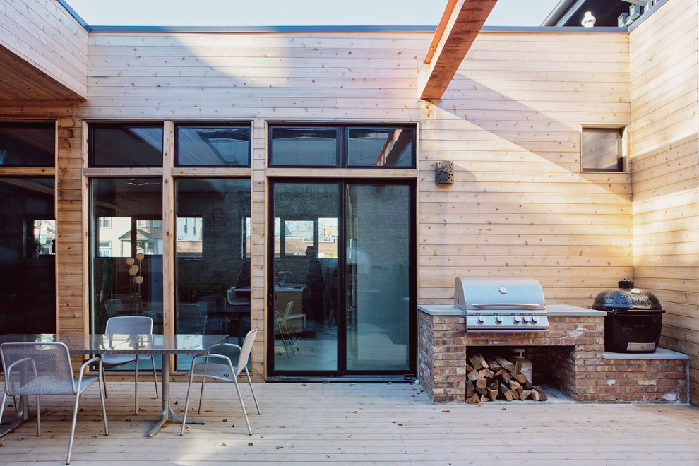 Photo of a large contemporary courtyard patio in Chicago with an outdoor kitchen, natural stone pavers and no cover.