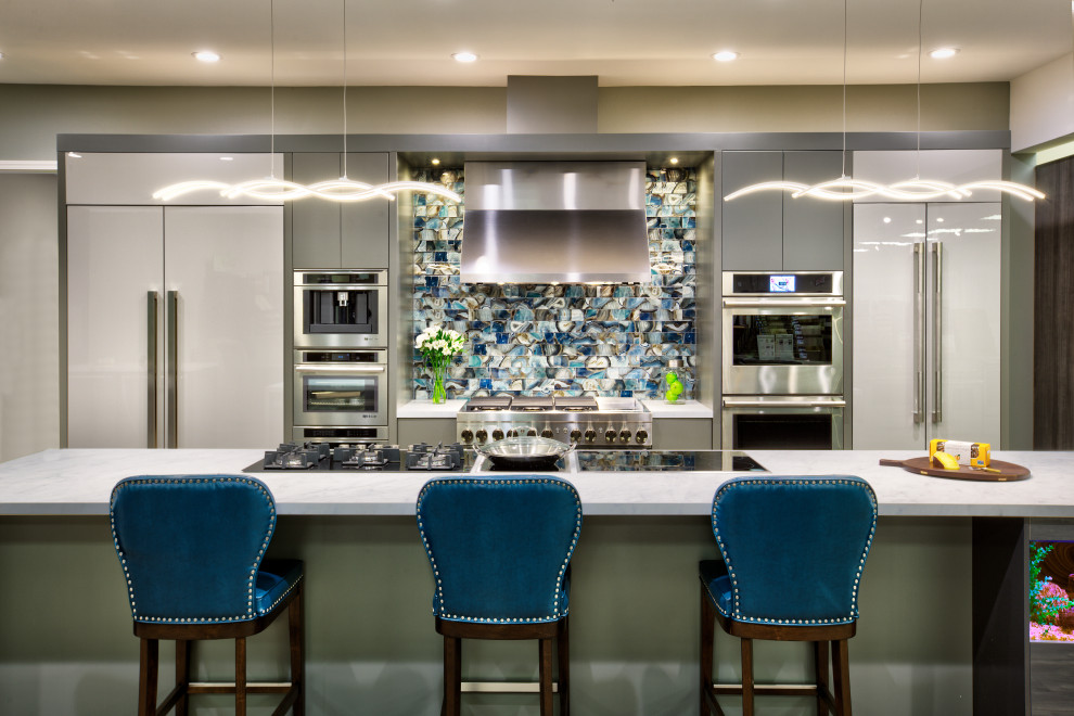 This is an example of a large contemporary single-wall eat-in kitchen in Sacramento with flat-panel cabinets, grey cabinets, quartz benchtops, blue splashback, glass tile splashback, stainless steel appliances, vinyl floors, with island, brown floor and white benchtop.