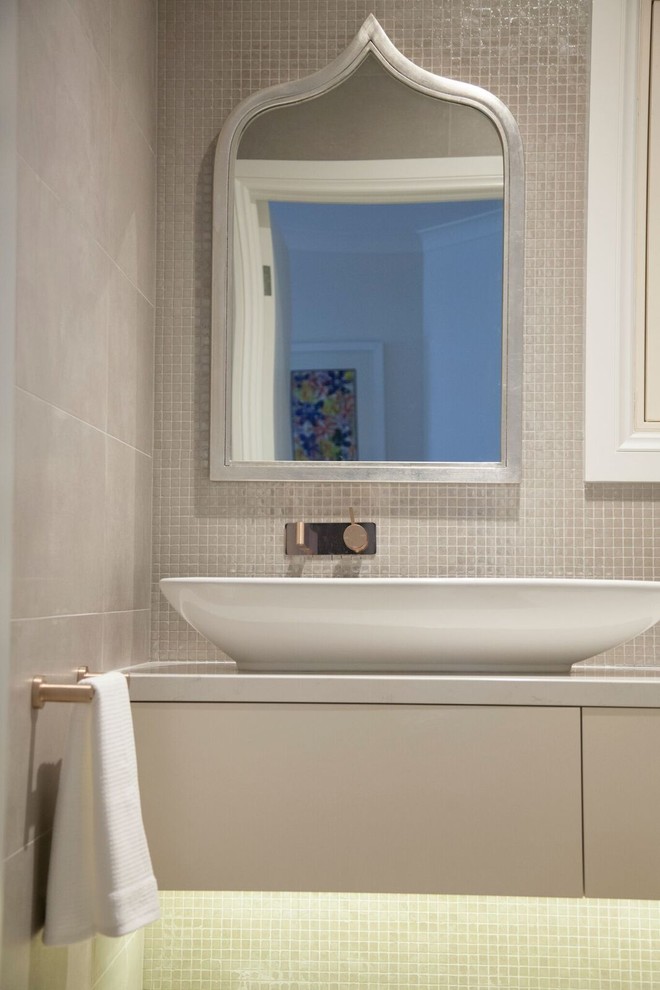 Small contemporary powder room in Sydney with flat-panel cabinets, white cabinets, a one-piece toilet, beige tile, mosaic tile and engineered quartz benchtops.