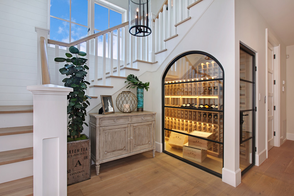 Inspiration for a beach style wine cellar in Orange County with medium hardwood floors, storage racks and yellow floor.