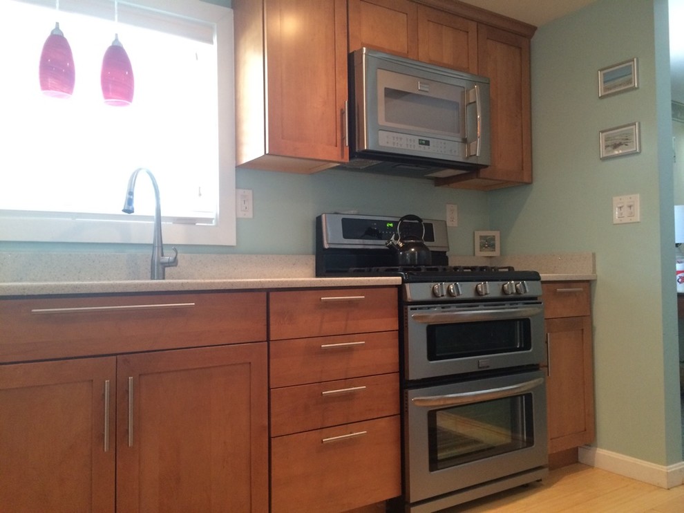 Inspiration for a transitional galley light wood floor eat-in kitchen remodel in Boston with an undermount sink, shaker cabinets, medium tone wood cabinets, quartz countertops, stainless steel appliances, no island and white countertops