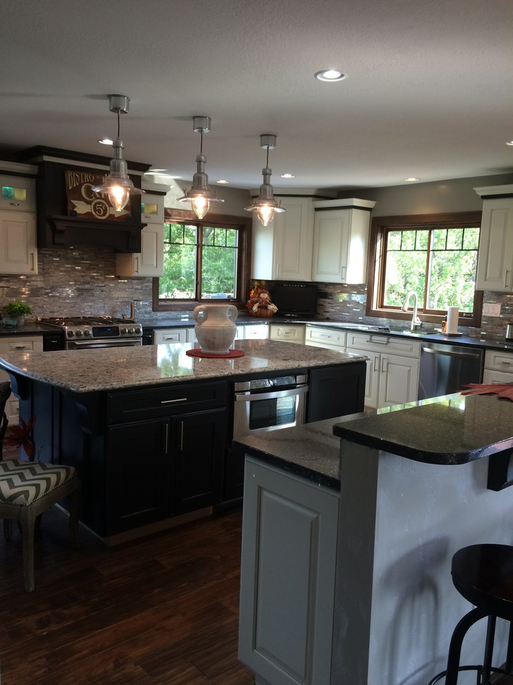 Large mountain style l-shaped eat-in kitchen photo with an undermount sink, raised-panel cabinets, white cabinets, quartz countertops, stainless steel appliances and two islands