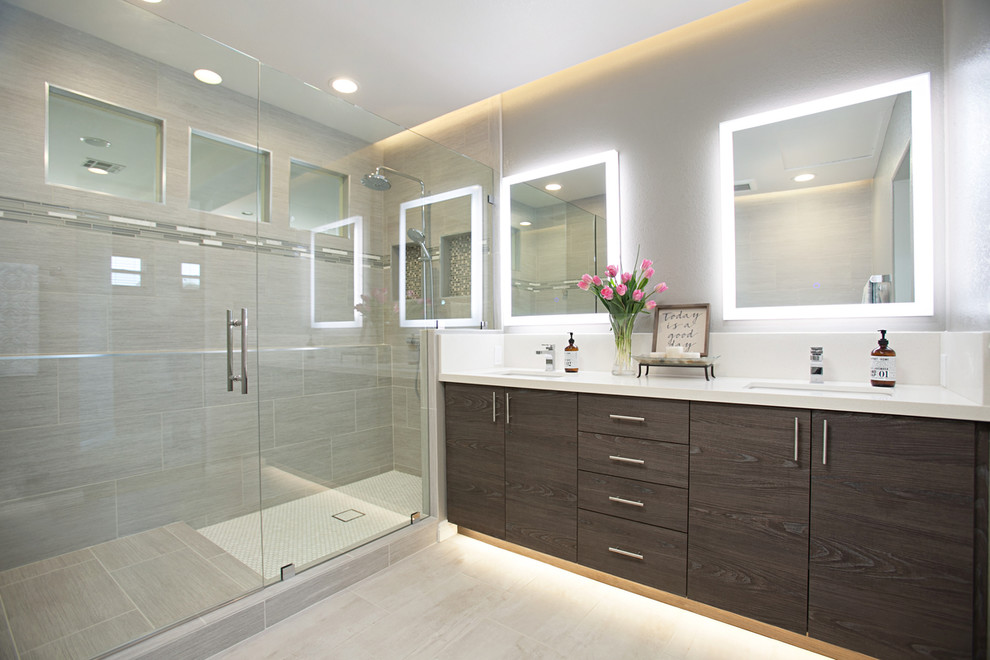 Inspiration for a large modern master bathroom in San Diego with raised-panel cabinets, dark wood cabinets, a corner shower, a two-piece toilet, gray tile, porcelain tile, grey walls, porcelain floors, an undermount sink, quartzite benchtops, grey floor and a hinged shower door.