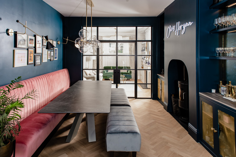 Aménagement d'une grande salle à manger contemporaine fermée avec un mur bleu, un sol en bois brun et un poêle à bois.