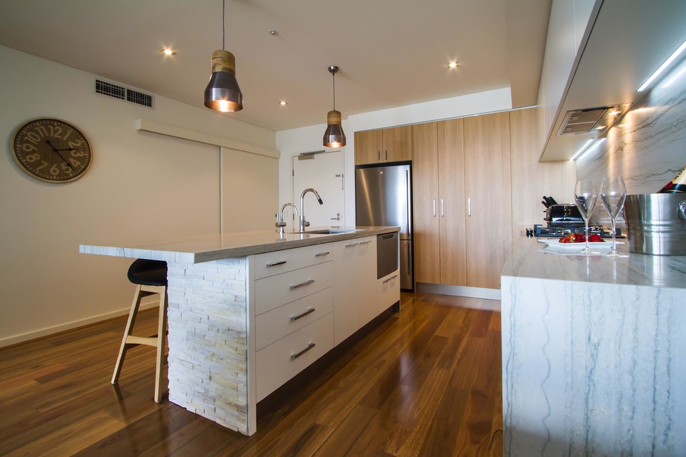 Inspiration for a small contemporary l-shaped eat-in kitchen in Melbourne with flat-panel cabinets, granite benchtops, stone slab splashback, medium hardwood floors and with island.