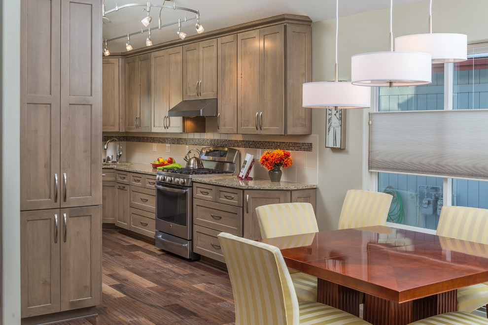 Inspiration for a mid-sized transitional galley medium tone wood floor eat-in kitchen remodel with an undermount sink, recessed-panel cabinets, gray cabinets, quartz countertops, beige backsplash, ceramic backsplash, stainless steel appliances and no island