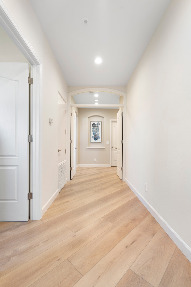 Esempio di un ingresso o corridoio moderno di medie dimensioni con pareti bianche, pavimento in vinile e pavimento beige