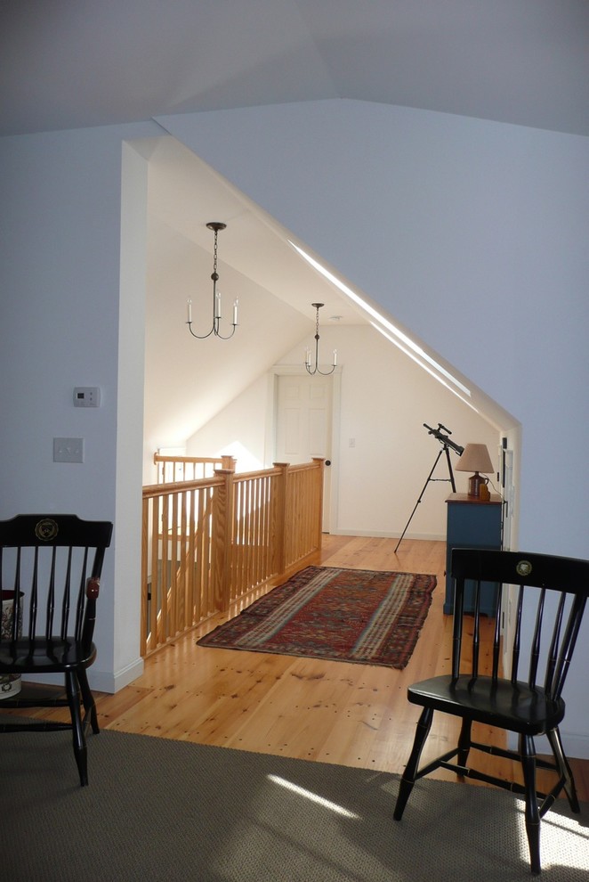 Photo of a mid-sized transitional hallway in Boston with white walls, medium hardwood floors and brown floor.
